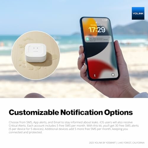 Person holding a smartphone displaying notifications on a beach.