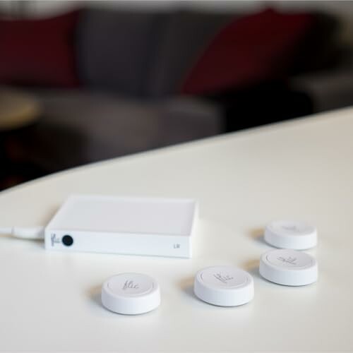 Wireless charging pads and a connected white device on a table.